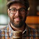 Man happily sipping coffee from a ceramic mug, warm ambient lighting