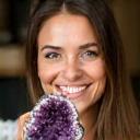 Smiling woman holding a polished geode, soft lighting